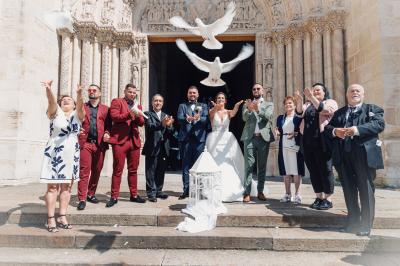 Un couple en tenue de mariage pose dans une forêt verdoyante, éclairée par une lumière douce.