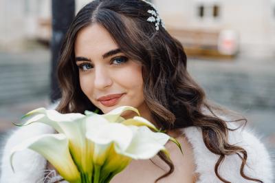 Un couple en tenue de mariage pose dans une forêt verdoyante, éclairée par une lumière douce.