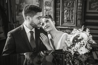 Un couple en tenue de mariage pose dans une forêt verdoyante, éclairée par une lumière douce.