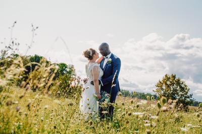 Un couple en tenue de mariage pose dans une forêt verdoyante, éclairée par une lumière douce.