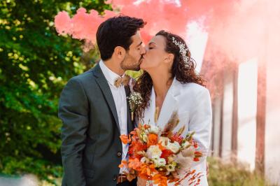 Un couple en tenue de mariage pose dans une forêt verdoyante, éclairée par une lumière douce.