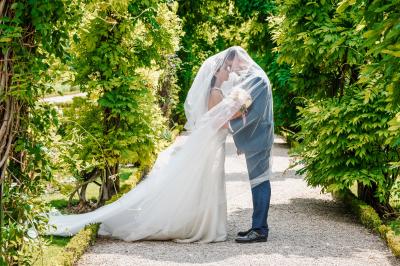 Un couple en tenue de mariage pose dans une forêt verdoyante, éclairée par une lumière douce.