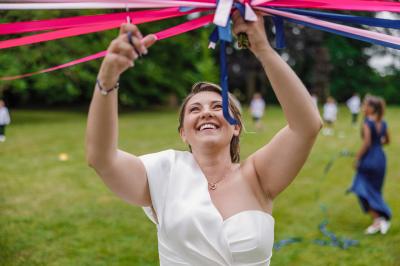 Un couple en tenue de mariage pose dans une forêt verdoyante, éclairée par une lumière douce.