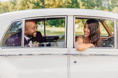 Un couple en tenue de mariage pose dans une forêt verdoyante, éclairée par une lumière douce.