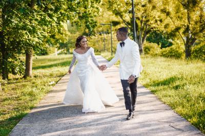 Un couple en tenue de mariage pose dans une forêt verdoyante, éclairée par une lumière douce.