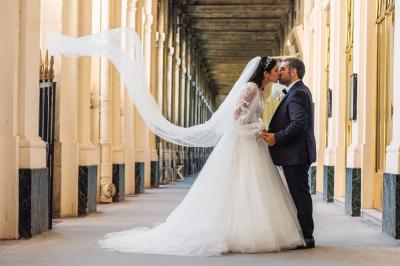 Un couple en tenue de mariage pose dans une forêt verdoyante, éclairée par une lumière douce.