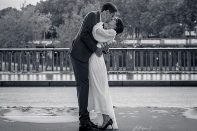 Un couple en tenue de mariage pose dans une forêt verdoyante, éclairée par une lumière douce.