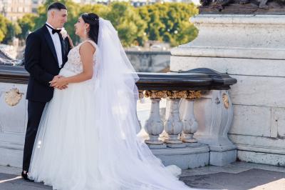 Un couple en tenue de mariage pose dans une forêt verdoyante, éclairée par une lumière douce.