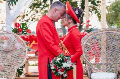 Un couple en tenue de mariage pose dans une forêt verdoyante, éclairée par une lumière douce.