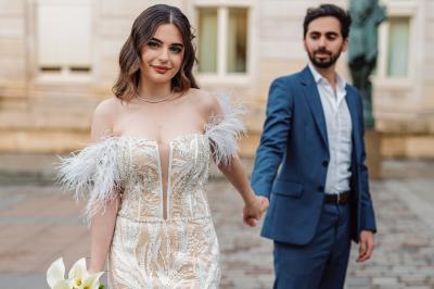 Un couple en tenue de mariage pose dans une forêt verdoyante, éclairée par une lumière douce.