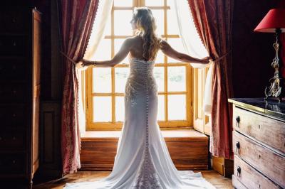 Un couple en tenue de mariage pose dans une forêt verdoyante, éclairée par une lumière douce.