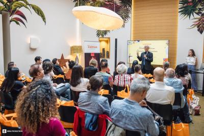 Des personnes assistent à une présentation dans une salle moderne avec un écran affichant un ordre du jour.