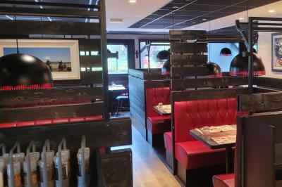 Entrée d'un restaurant avec une enseigne ’Buffalo Grill’ et une porte vitrée affichant des autocollants.