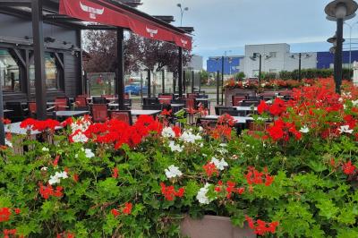 Entrée d'un restaurant avec une enseigne ’Buffalo Grill’ et une porte vitrée affichant des autocollants.