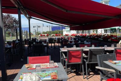 Entrée d'un restaurant avec une enseigne ’Buffalo Grill’ et une porte vitrée affichant des autocollants.