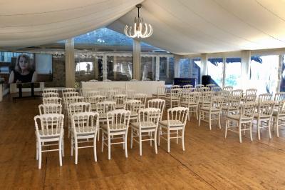 Salle de bain lumineuse avec miroirs, baignoire, serviettes orange et sol en carrelage rouge.