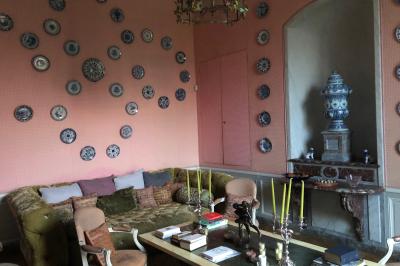 Salle de bain lumineuse avec miroirs, baignoire, serviettes orange et sol en carrelage rouge.