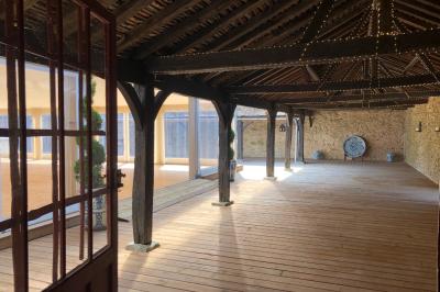 Salle de bain lumineuse avec miroirs, baignoire, serviettes orange et sol en carrelage rouge.