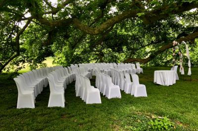 Salle de bain lumineuse avec baignoire, lavabo fleuri, miroirs, serviettes rouges et plafond peint en ciel nuageux.
