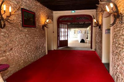 Salle de bain lumineuse avec baignoire, lavabo fleuri, miroirs, serviettes rouges et plafond peint en ciel nuageux.