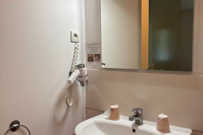 Viande en train de rôtir sur une broche au-dessus d'un barbecue en plein air, dans un jardin verdoyant.