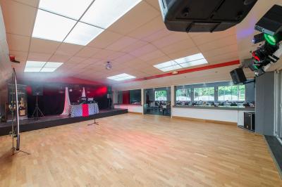 Viande en train de rôtir sur une broche au-dessus d'un barbecue en plein air, dans un jardin verdoyant.