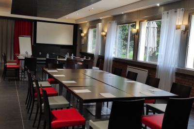 Viande en train de rôtir sur une broche au-dessus d'un barbecue en plein air, dans un jardin verdoyant.