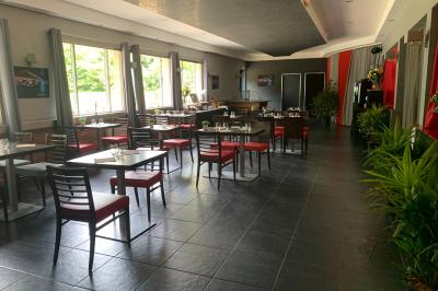 Viande en train de rôtir sur une broche au-dessus d'un barbecue en plein air, dans un jardin verdoyant.