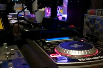 Salle de réception décorée avec des tables dressées et un plan rapproché d'une console de mixage audio.