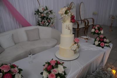 Centre de table élégant avec des roses blanches et des pampilles en cristal, entouré de vaisselle sur une nappe blanche.