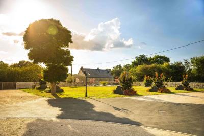 Cuisine professionnelle avec évier en inox, lave-vaisselle industriel, chariots noirs et casiers empilés sur sol carrelé.