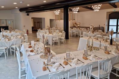 Cuisine professionnelle avec évier en inox, lave-vaisselle industriel, chariots noirs et casiers empilés sur sol carrelé.