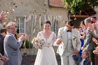Cuisine professionnelle avec évier en inox, lave-vaisselle industriel, chariots noirs et casiers empilés sur sol carrelé.