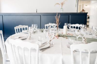 Cuisine professionnelle avec évier en inox, lave-vaisselle industriel, chariots noirs et casiers empilés sur sol carrelé.