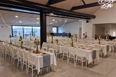 Cuisine professionnelle avec évier en inox, lave-vaisselle industriel, chariots noirs et casiers empilés sur sol carrelé.