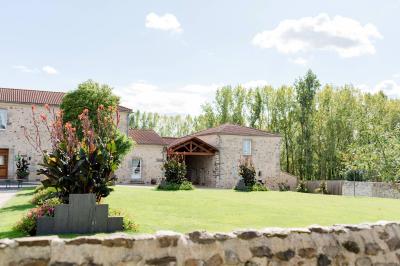Cuisine professionnelle avec évier en inox, lave-vaisselle industriel, chariots noirs et casiers empilés sur sol carrelé.