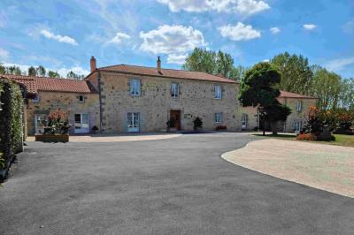 Cuisine professionnelle avec évier en inox, lave-vaisselle industriel, chariots noirs et casiers empilés sur sol carrelé.