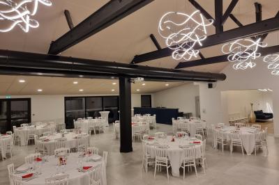 Cuisine professionnelle avec évier en inox, lave-vaisselle industriel, chariots noirs et casiers empilés sur sol carrelé.