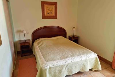 Cuisine professionnelle avec évier en inox, lave-vaisselle industriel, chariots noirs et casiers empilés sur sol carrelé.