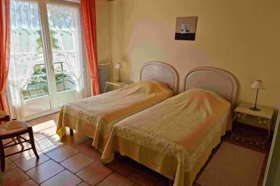 Cuisine professionnelle avec évier en inox, lave-vaisselle industriel, chariots noirs et casiers empilés sur sol carrelé.