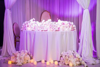 Façade d'un bâtiment moderne éclairé de nuit, avec des plantes et un panneau ’La Scène’ visible.