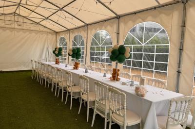 Façade d'un bâtiment moderne éclairé de nuit, avec des plantes et un panneau ’La Scène’ visible.