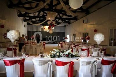 Bâtisse provençale entourée de cyprès et de champs verts, avec des arbres en arrière-plan sous un ciel clair.