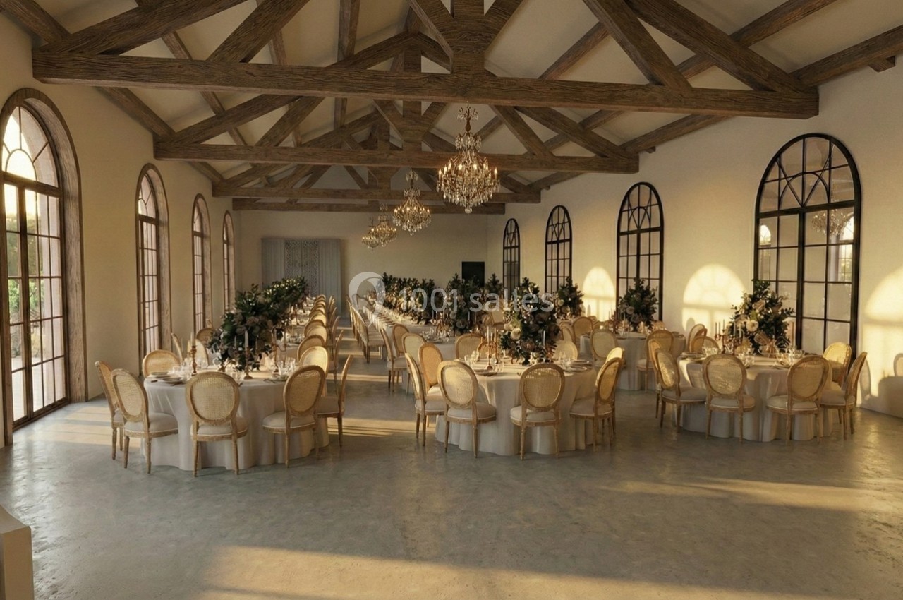 Grande salle de réception lumineuse avec des tables rondes décorées, des chaises en bois clair et des lustres suspendus.
