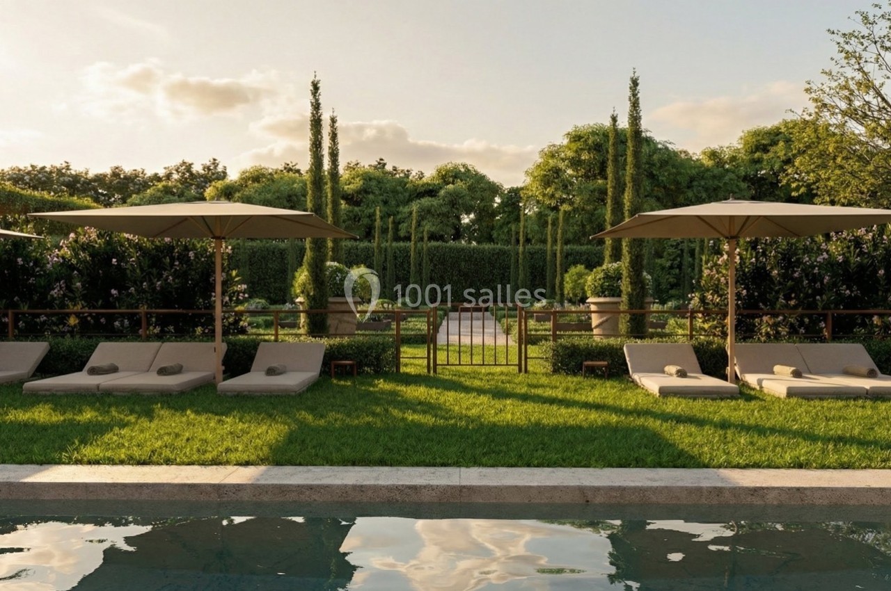 Chaises longues et parasols disposés sur une pelouse près d'une piscine, entourés de haies et d'arbres.
