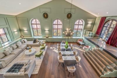 Un coin café moderne installé dans une alcôve en pierre ancienne avec une fresque et des colonnes décoratives.