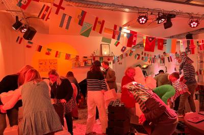 Des personnes construisent des structures avec de grands blocs en plastique dans une salle décorée sur le thème de l'Égypte.