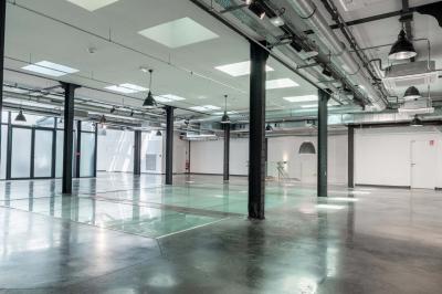 Salle de bain moderne avec murs et sols en finition bois, lavabo collectif et éclairage encastré.