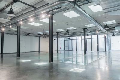 Salle de bain moderne avec murs et sols en finition bois, lavabo collectif et éclairage encastré.