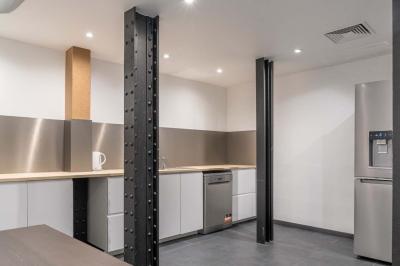 Salle de bain moderne avec murs et sols en finition bois, lavabo collectif et éclairage encastré.